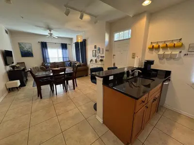 a kitchen and living room with a table and a dining room at 4 Bedroom 3 Bathroom Villas At SevenDwarfs 31-107 in Kissimmee
