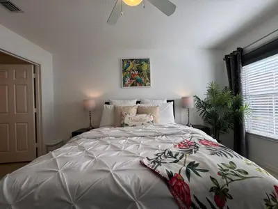a bedroom with a large bed with a white comforter at 4 Bedroom 3 Bathroom Villas At SevenDwarfs 31-107 in Kissimmee
