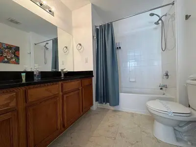 a bathroom with a tub and a toilet and a sink at 4 Bedroom 3 Bathroom Villas At SevenDwarfs 31-107 in Kissimmee