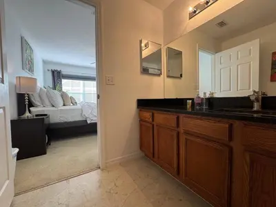 a bathroom with a sink and a room with a bed at 4 Bedroom 3 Bathroom Villas At SevenDwarfs 31-107 in Kissimmee