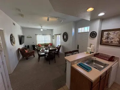 a kitchen and living room with a table and a dining room at 4 Bedroom 3 Bathroom Villas At SevenDwarfs 28-107 in Kissimmee