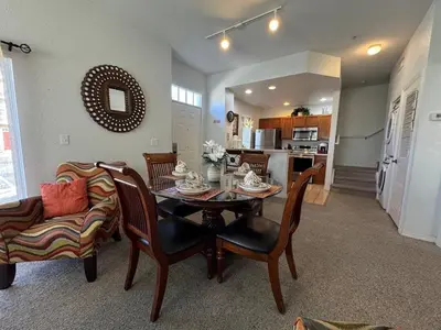 a living room with a table and chairs and a kitchen at 4 Bedroom 3 Bathroom Villas At SevenDwarfs 28-107 in Kissimmee
