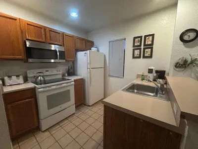 a kitchen with a white refrigerator and a sink at 4 Bedroom 3 Bathroom Villas At SevenDwarfs 22-108 in Kissimmee