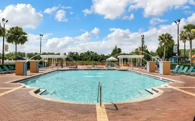 a pool at a resort with chairs and a playground at 4 Bedroom 3 Bathroom Villas At SevenDwarfs 22-108 in Kissimmee