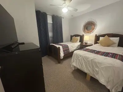 a bedroom with two beds and a flat screen tv at 4 Bedroom 3 Bathroom Villas At SevenDwarfs 22-108 in Kissimmee