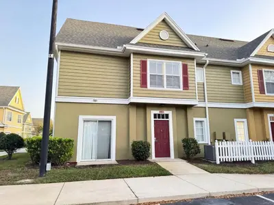 a house with a red door on a street at 4 Bedroom 3 Bathroom Villas At SevenDwarfs 22-108 in Kissimmee