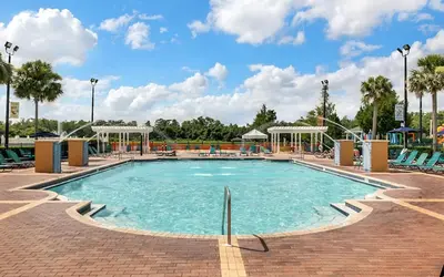 a pool at a resort with chairs and a playground at 3 Bedroom 2 Bathroom Villas At SevenDwarfs 19-106 in Kissimmee