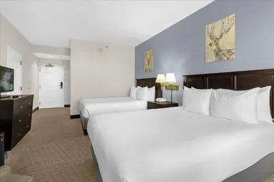 a hotel room with two beds and a television at Studio Apartment w Pool & Hot Tub - Near Universal Studio in Orlando
