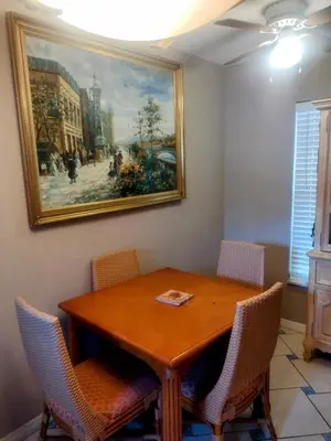 a dining room table with chairs and a painting on the wall at A peaceful living vibe in Orlando