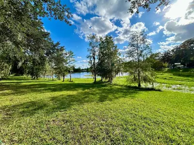 a park with trees and a lake in the background at Your home away from home! Entire cottage- Disney in Kissimmee