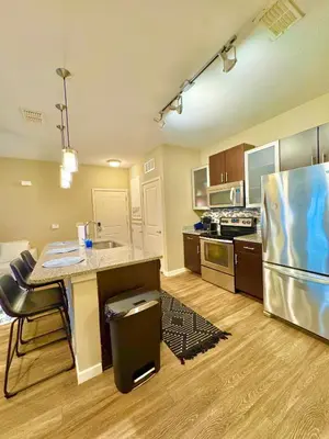 a large kitchen with a table and a refrigerator at Chic 1-Bedroom Apt in Lake Nona in Orlando