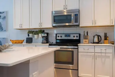 a kitchen with white cabinets and a microwave at Luxury Lakeview Home Private Pool 2687 in Kissimmee
