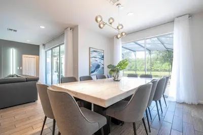 a dining room with a large wooden table and chairs at Luxury Lakeview Home Private Pool 2687 in Kissimmee