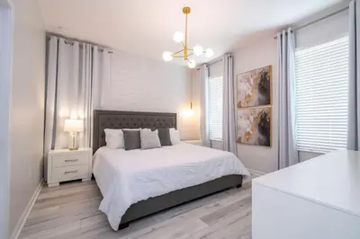 a white bedroom with a bed and a white table at Luxury Lakeview Home Private Pool 2687 in Kissimmee