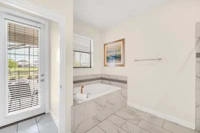 a white bathroom with a tub and a window at Lakefront Luxury Retreat Private Pool & Movie Theater 367 in Kissimmee