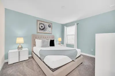 a bedroom with a white bed and blue walls at Lakefront Luxury Retreat Private Pool & Movie Theater 367 in Kissimmee