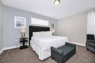 a bedroom with a large white bed and a chair at Marvelous Home With Private Pool And Waterpark & Resort Access Near Disney At Encore Resorts Reunion - 7464Mr in Kissimmee