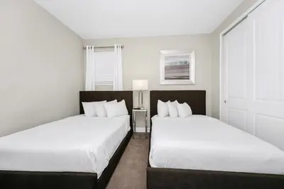 two beds in a small room with white walls at Marvelous Home With Private Pool And Waterpark & Resort Access Near Disney At Encore Resorts Reunion - 7464Mr in Kissimmee