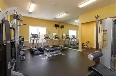 a gym with a bunch of treadmills and machines at Modern Guesthouse near MCO in Kissimmee
