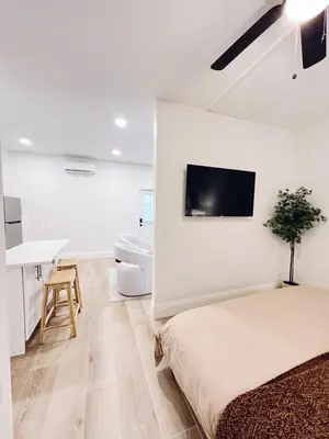 a bedroom with a bed and a flat screen tv on the wall at Modern Guesthouse near MCO in Kissimmee
