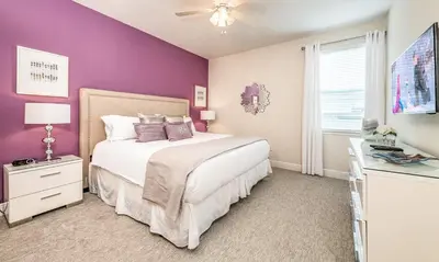 a bedroom with a white bed and purple walls at Ultimate 5 Star Villa with Private Pool on Encore Resort at Reunion Orlando Villa 4391 in Orlando