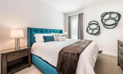 a bedroom with a large bed with a blue headboard at Luxury Private Villa with Large Pool on Encore Resort at Reunion Orlando Villa 4433 in Orlando