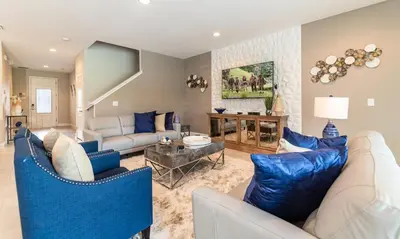 a living room with a white couch and blue chairs at Rent the Perfect 8 Bedroom Villa on Encore Resort at Reunion Orlando Villa 4474 in Orlando