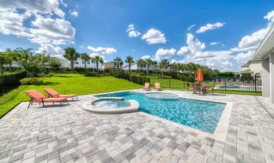 a backyard with a pool and chairs and a lawn at Rent the Perfect 8 Bedroom Villa on Encore Resort at Reunion Orlando Villa 4474 in Orlando