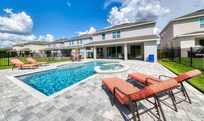 a swimming pool with two chairs and a house at Rent the Perfect 8 Bedroom Villa on Encore Resort at Reunion Orlando Villa 4474 in Orlando