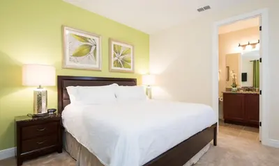 a bedroom with a large bed and a bathroom at 5 Star Villa on Orlando’s most Exclusive Encore Resort at Reunion Orlando Villa 4355 in Orlando