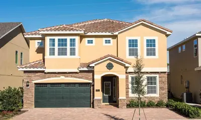 a house with a green garage at 5 Star Villa on Orlando’s most Exclusive Encore Resort at Reunion Orlando Villa 4355 in Orlando