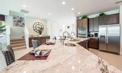 a large kitchen with a large marble counter top at 5 Star Villa on Orlando’s most Exclusive Encore Resort at Reunion Orlando Villa 4377 in Orlando
