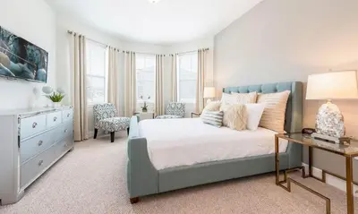 a bedroom with a blue bed and a desk and chair at 5 Star Villa on Orlando’s most Exclusive Encore Resort at Reunion Orlando Villa 4377 in Orlando