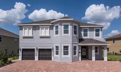 a house with two garage doors on a driveway at 5 Star Villa on Orlando’s most Exclusive Encore Resort at Reunion Orlando Villa 4377 in Orlando