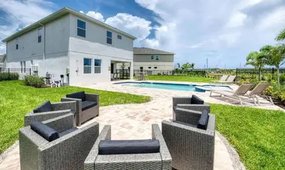 a house with a swimming pool and some chairs at 5 Star Villa on Orlando’s most Exclusive Encore Resort at Reunion Orlando Villa 4507 in Orlando