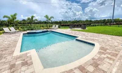 a swimming pool in a yard with two lounge chairs at 5 Star Villa on Orlando’s most Exclusive Encore Resort at Reunion Orlando Villa 4507 in Orlando