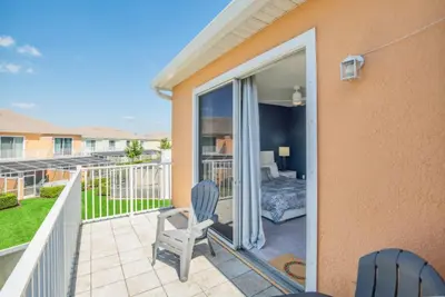 a room with a balcony with a chair and a bedroom at Modern Townhome with 3 Bedrooms 5506 in Orlando