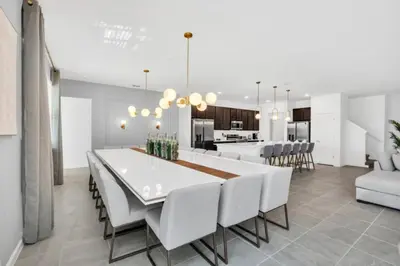 a dining room and kitchen with a white table and chairs at Amazing Mansion on Veranda Palms Resort with the Best 5 Star Amenities Orlando Mansion 5533 in Kissimmee