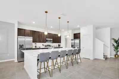 a kitchen with a large white island with bar stools at Amazing Mansion on Veranda Palms Resort with the Best 5 Star Amenities Orlando Mansion 5533 in Kissimmee