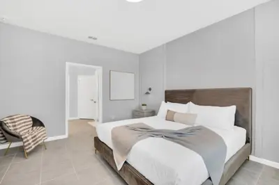 a white bedroom with a large bed and a chair at Amazing Mansion on Veranda Palms Resort with the Best 5 Star Amenities Orlando Mansion 5533 in Kissimmee
