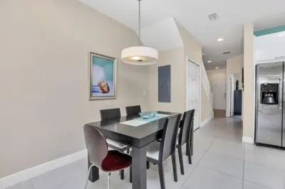 a dining room with a black table and chairs at 3BR Townhome with Stunning Views 5528 in Orlando