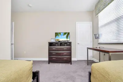 a bedroom with two beds and a desk and a tv at 3BR Townhome with Stunning Views 5528 in Orlando