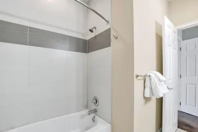 a white bathroom with a tub and a shower at 3BR Townhome with Stunning Views 5528 in Orlando