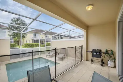 a balcony with a pool and a table and chairs at 3BR Townhome with Stunning Views 5528 in Orlando