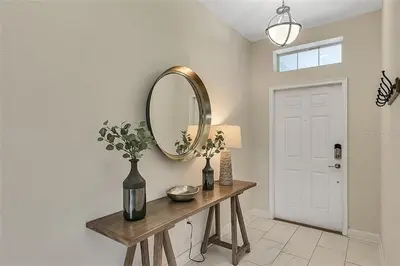 a room with a mirror and a table with flowers at You Will Love this 5 Star Villa located on Storey Lake Resort Orlando villa 5492 in Kissimmee