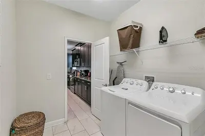 a white laundry room with a sink and a kitchen at You Will Love this 5 Star Villa located on Storey Lake Resort Orlando villa 5492 in Kissimmee