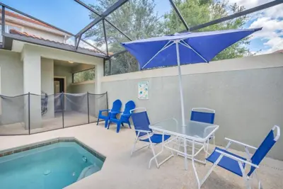 a patio with a table and chairs and an umbrella at Luxury 5 Star Villa on Paradise Palms ResortMinutes from Disney World Orlando Townhome 5502 in Kissimmee