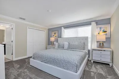 a bedroom with a bed and two night stands with lamps at Imagine You and Your Family Renting this 5 Star Villa on Storey Lake Resort Orlando Townhome 5519 in Kissimmee