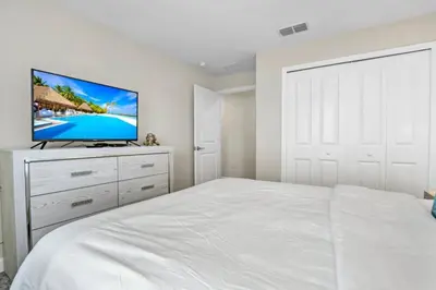 a bedroom with a white bed and a flat screen tv at Imagine You and Your Family Renting this 5 Star Villa on Storey Lake Resort Orlando Townhome 5519 in Kissimmee