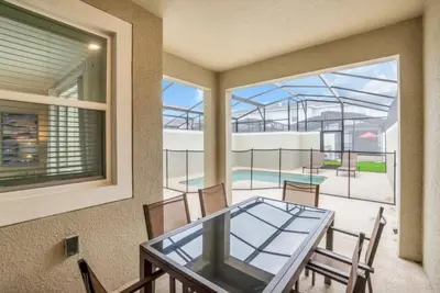 a dining room with a glass table and a balcony at Imagine You and Your Family Renting this 5 Star Villa on Storey Lake Resort Orlando Townhome 5519 in Kissimmee